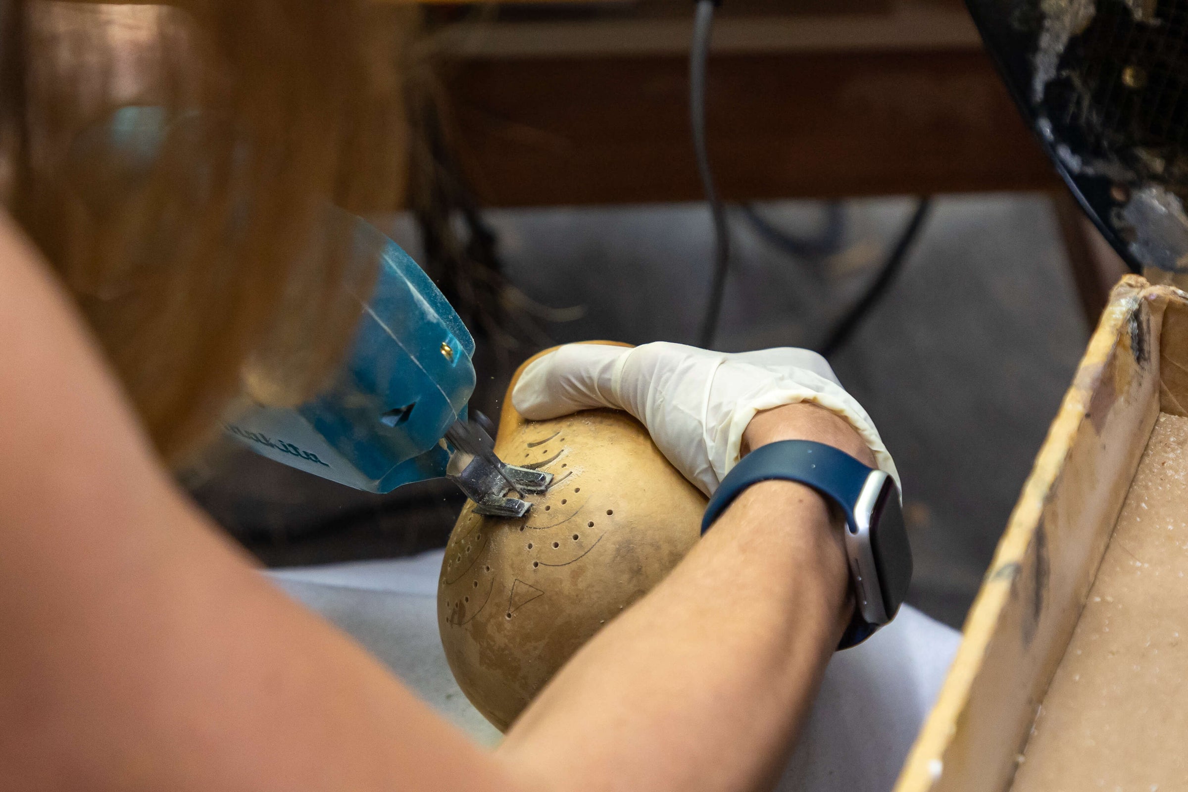 Crafter cutting a tree in a gourd with a jigsaw at Meadowbrooke Gourds.